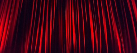 The cover picture shows a closed, red theatre curtain.