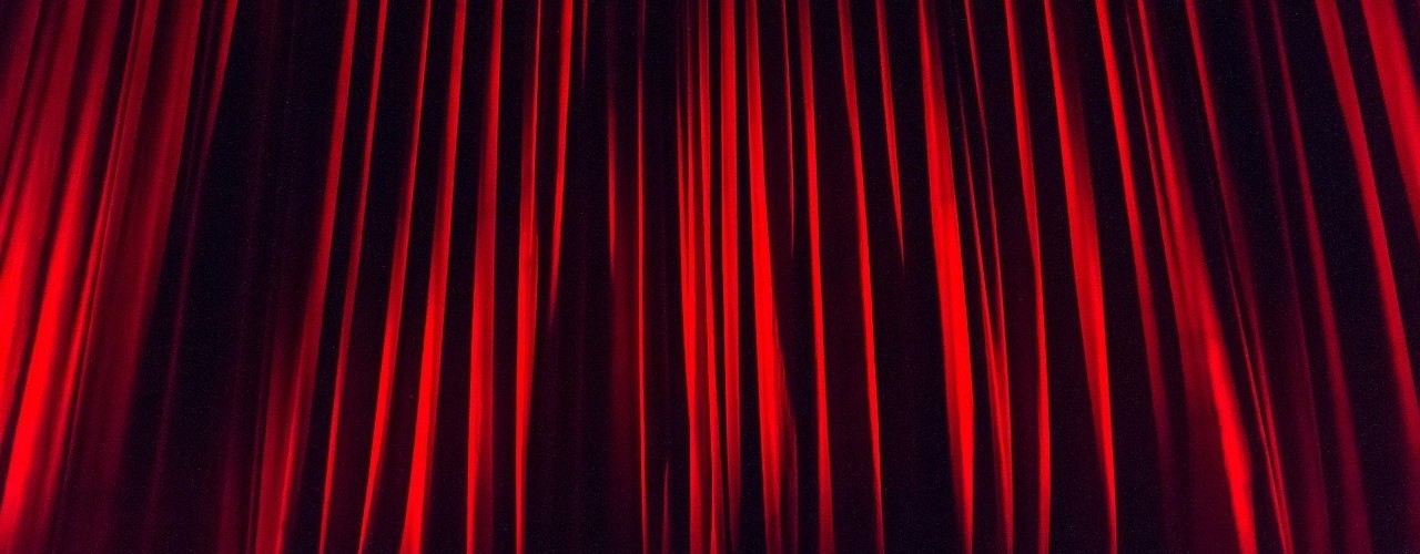 The cover picture shows a closed, red theatre curtain.