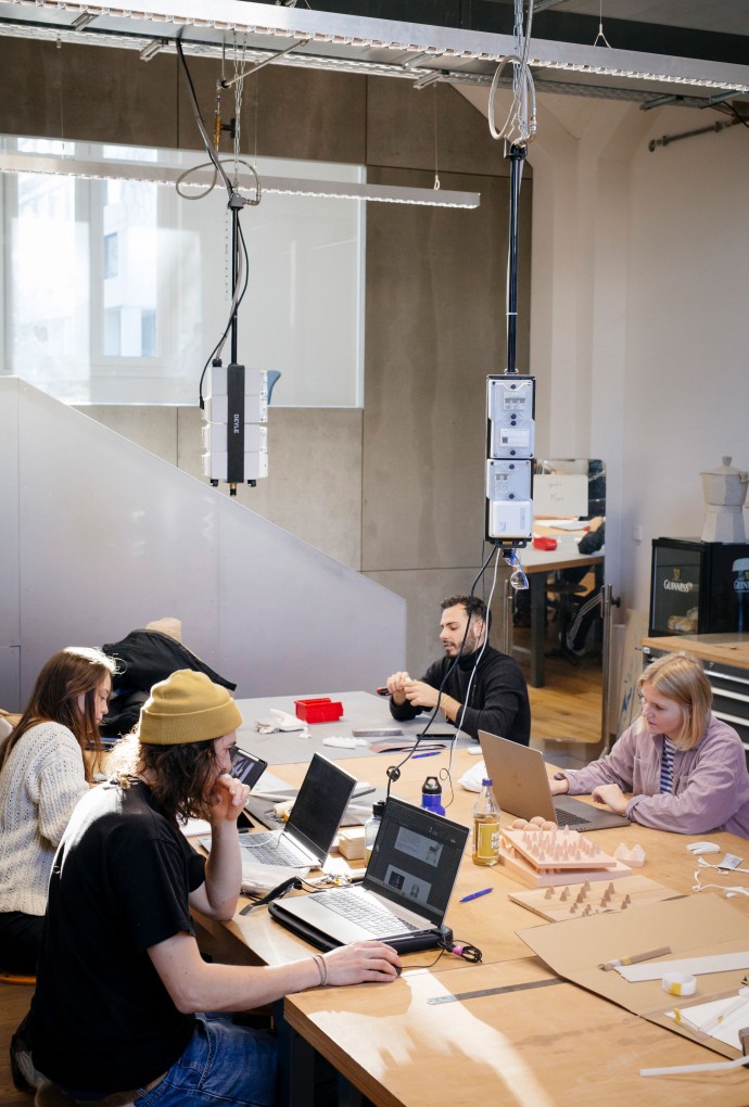 Studierende vor Bildschirmen bei Gruppenarbeit