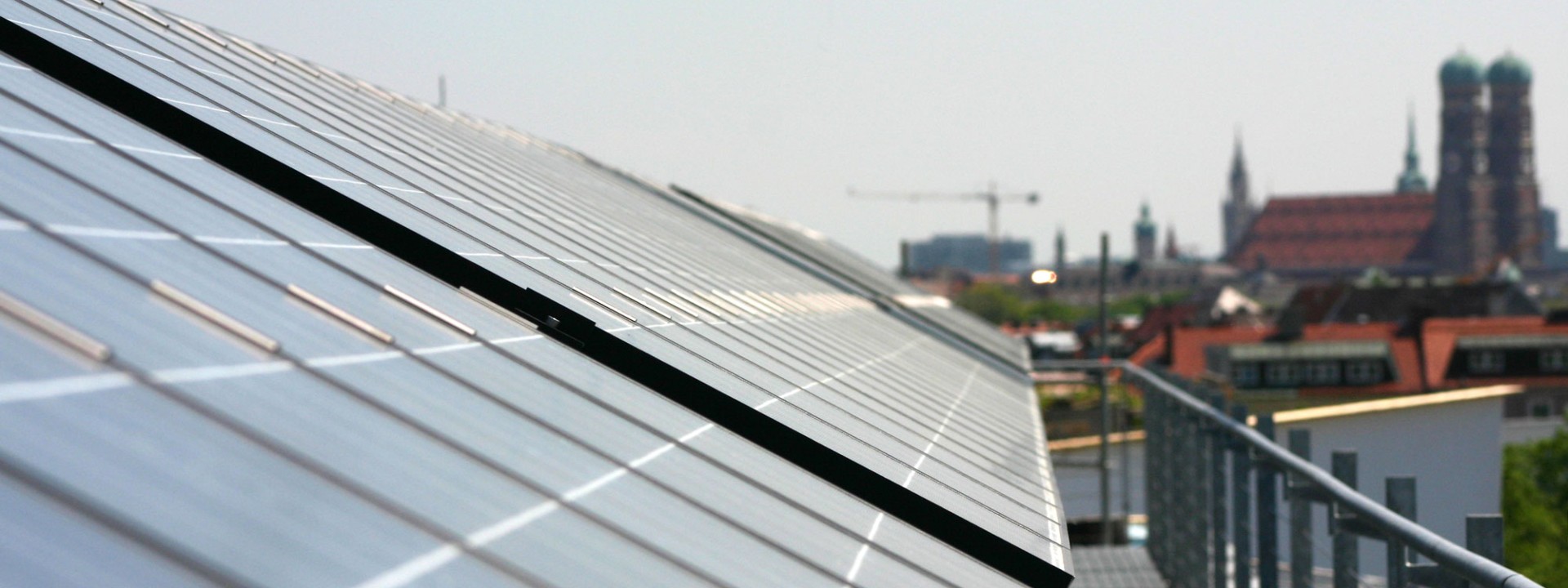 Blick über Solarpanele auf dem Dach eines HM-Gebäudes zur Frauenkirche
