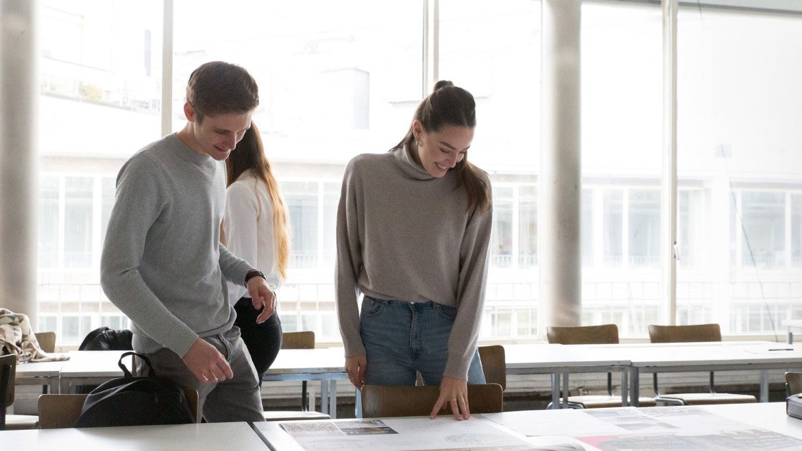Studierende vor Skizzen auf Tisch (Foto: Sigrid Reinichs) Studierende vor Skizzen auf Tisch