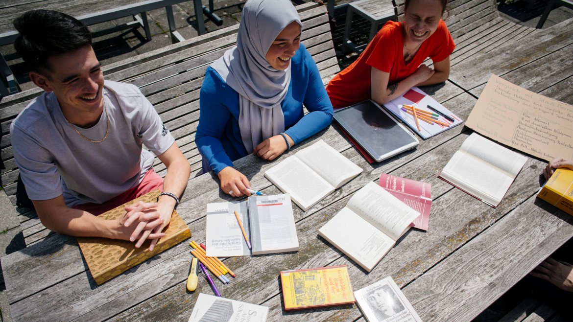 Eine Gruppe Studierender arbeitet gemeinsam an einem Tisch