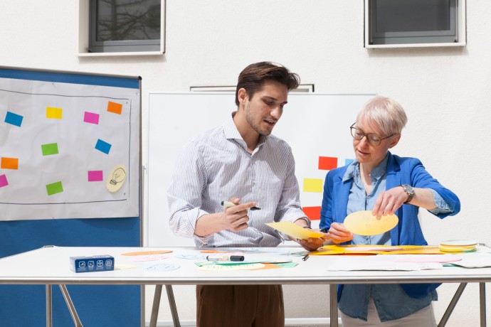 Dozentin und Studierender unterhalten sich