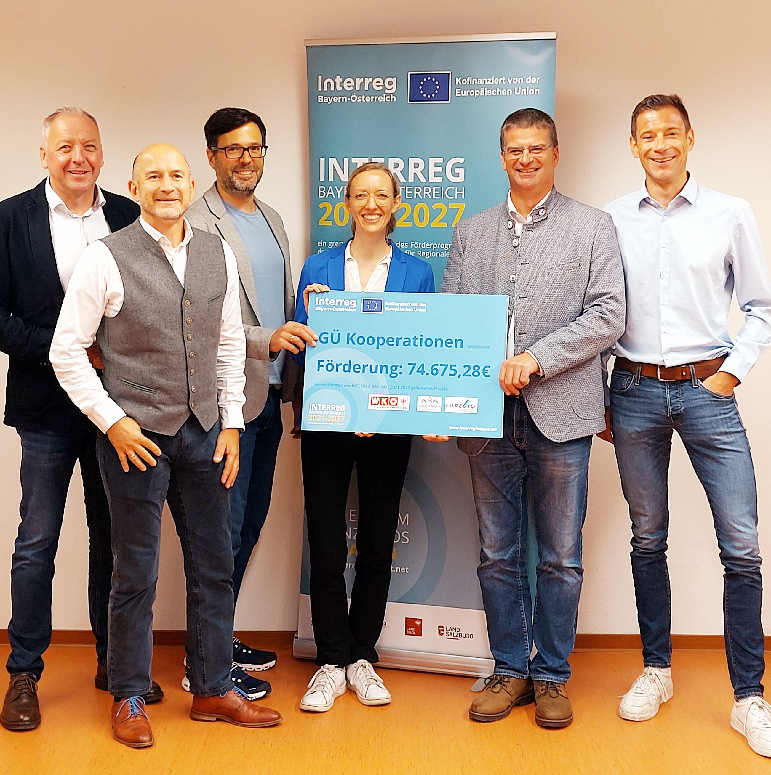 Auf dem Bild ist ein Foto der Teilnehmer des Kick-Offs zu sehen. Bild von links: Wolfgang Winkler (Wirtschaftskammer Tirol – Reutte), Sebastian Kramer (Zugspitz Region GmbH), Prof. Dr. Matthias Firgo (Hochschule München), Dr. Elisabeth Bartl (Hochschule München & TIZIO), Christan Hornsteiner (stellvertretender Landrat Garmisch-Partenkirchen), Mag. Stefan Wanner (Wirtschaftskammer Tirol – Innsbruck Land) bei der Förderscheckübergabe