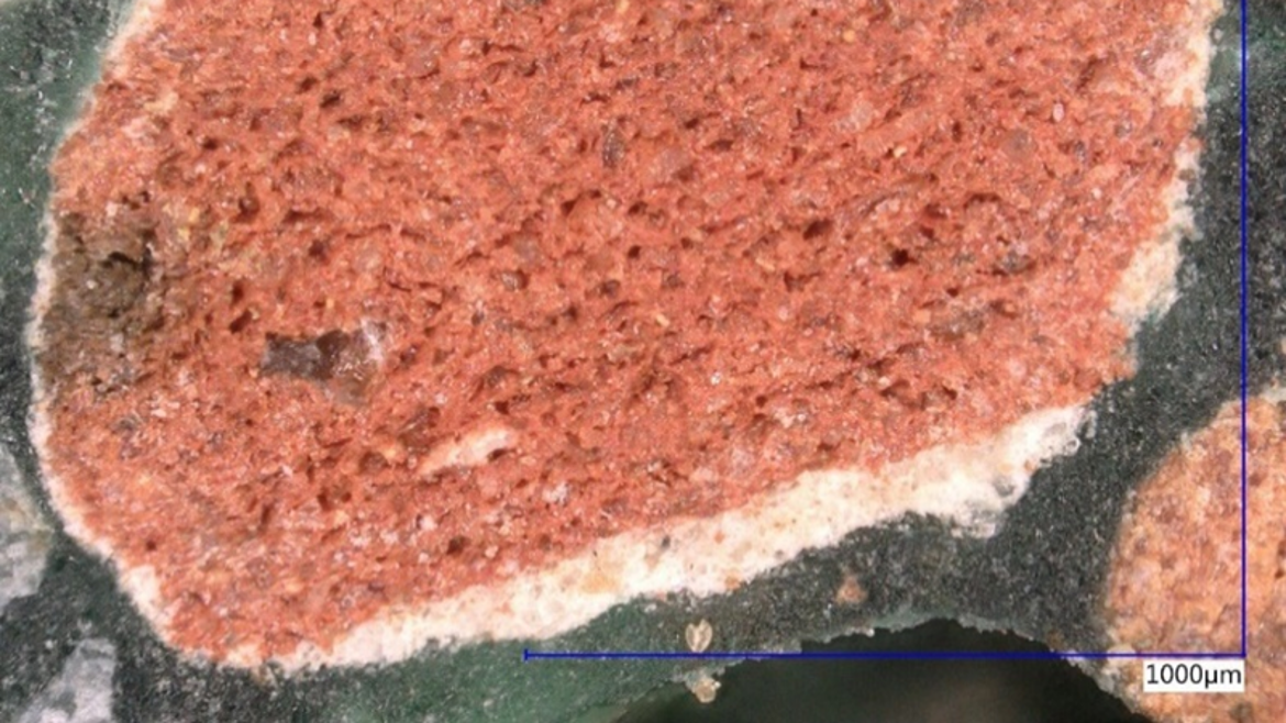 rezykliertes Gesteinskorn aus Mauerwerksabbruch mit aussenliegender Kalkschicht aus MICP Beaufschlagung