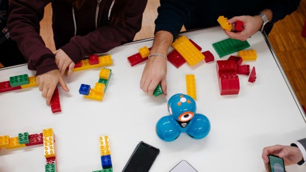 Forschende bauen mit Lego-Duplo-Steinen.