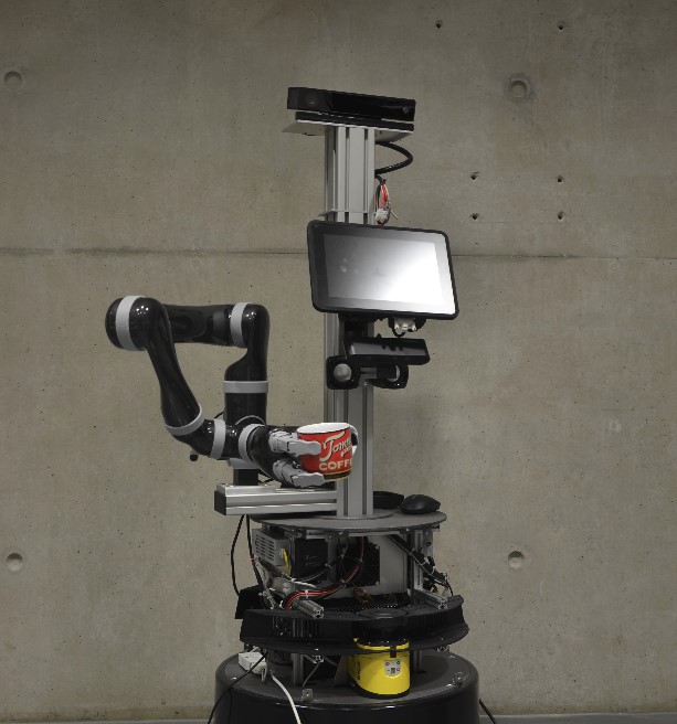 Assistenzroboter (Alfred Schöttl) Roboter reicht eine Tasse an.