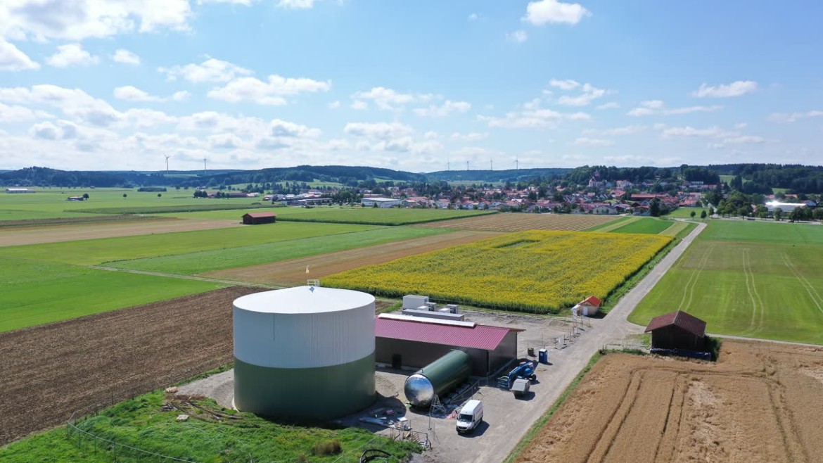 Im Vordergrund die Wärme- und Batteriespeicher, hinten mittig die vier Windkraftanlagen der Gemeinde