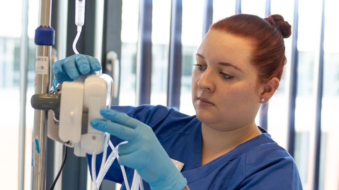 Medizinische Fachperson bereitet Infusion vor 