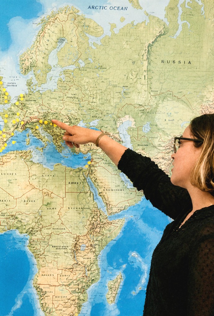 Two woman standing infront of a world map 