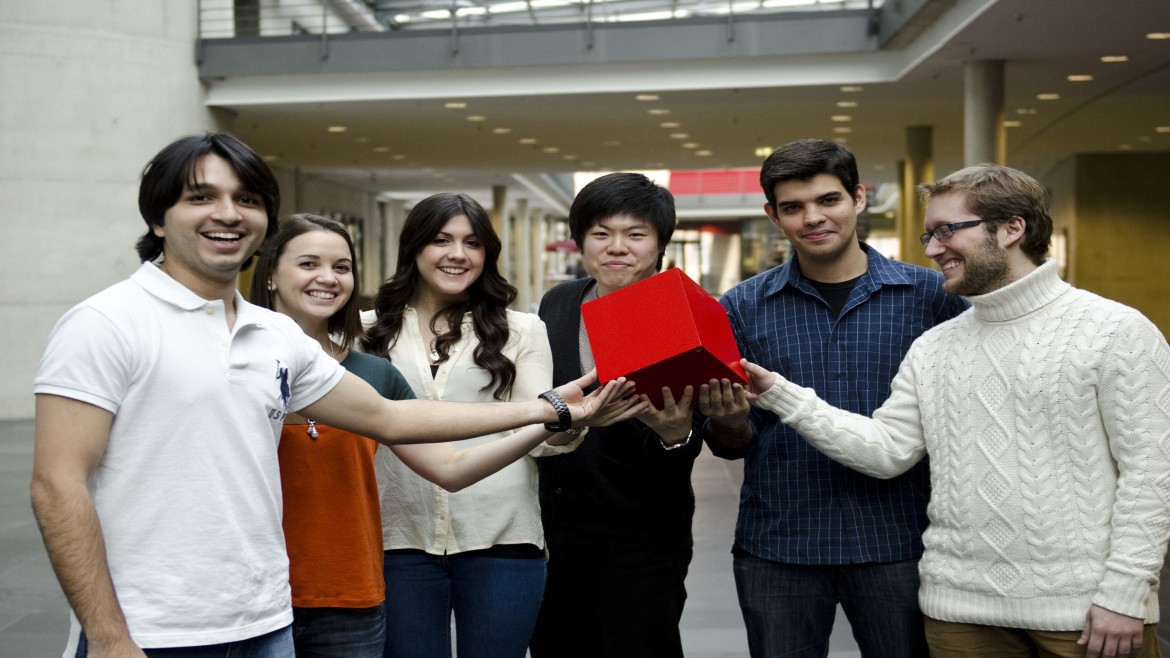 Gruppe von Studierenden, die einen roten Würfel halten.