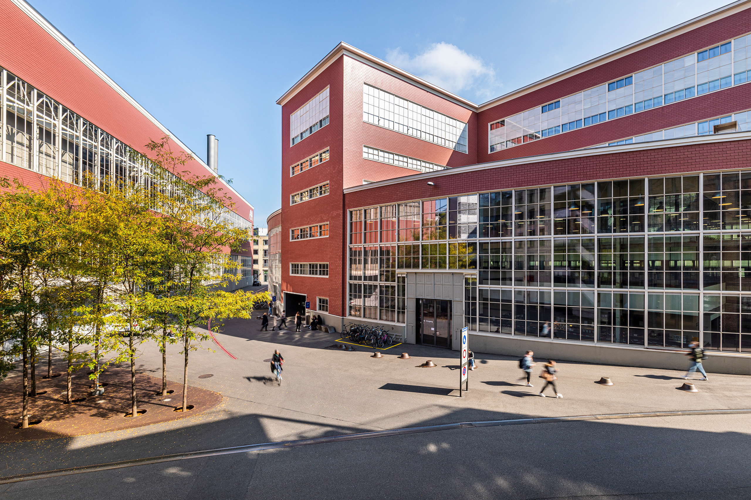 Building at Campus Stadt-Mitte in Winterthur, brick-red building, forecourt with trees