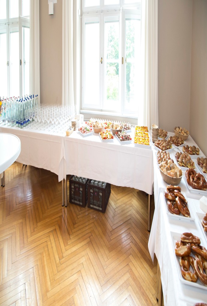 Tables with various food such as pretzels and drinks and glasses at the Summer School's Welcome Day