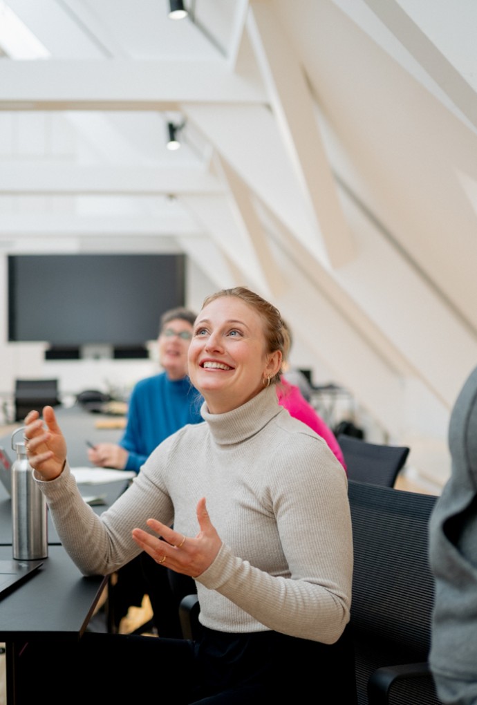 Referentin hält Vortrag vor sitzenden Teilnehmenden während eines Workshops zu Feminismus