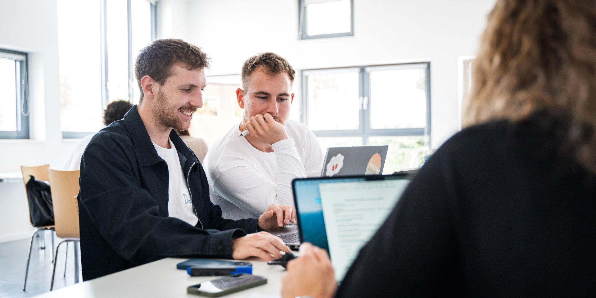 Studenten der Hochschule München informieren sich über Wahlempfehlungen am Laptop. 