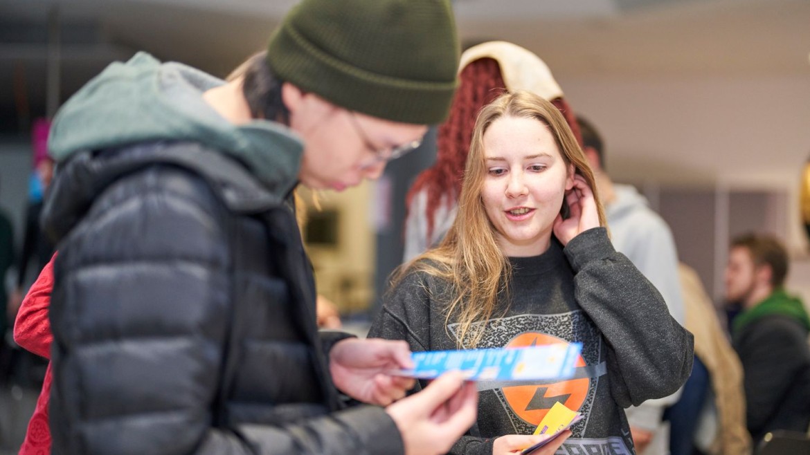 Internationale Studierende der HM lesen Infomaterial 
