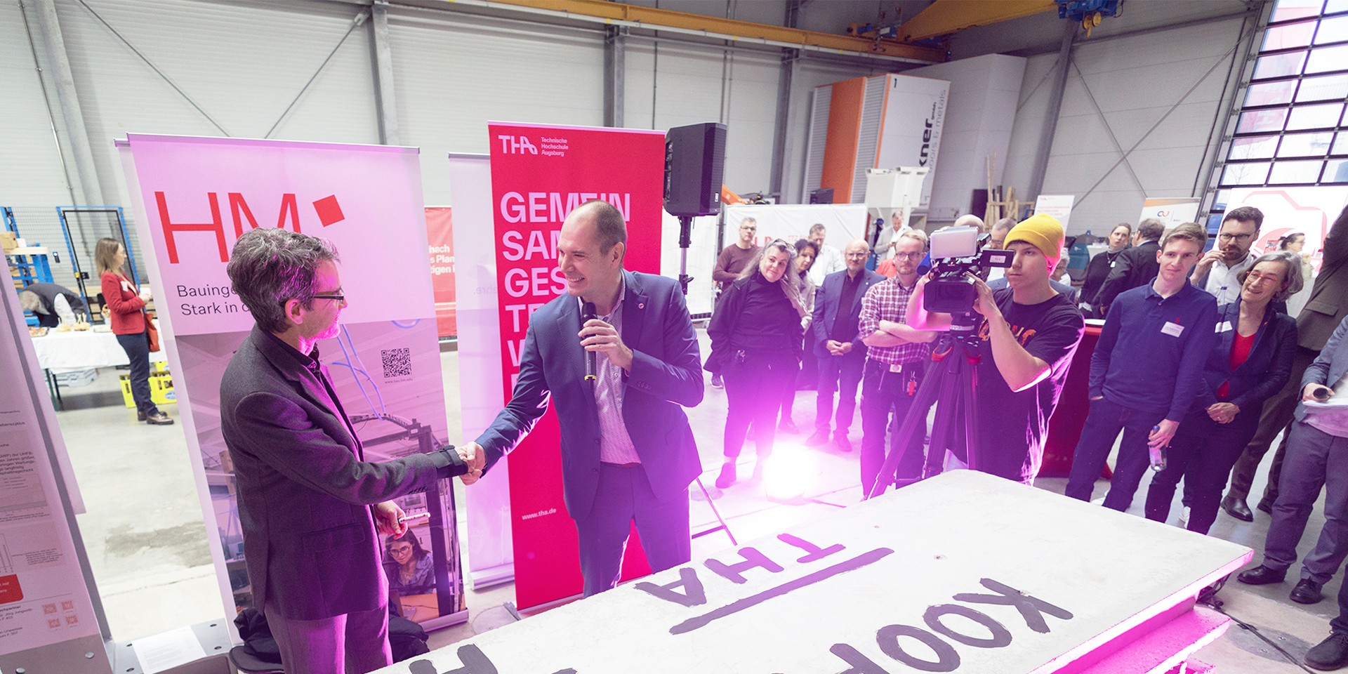 Professoren der beiden Hoschschulen schütteln sich die Hände