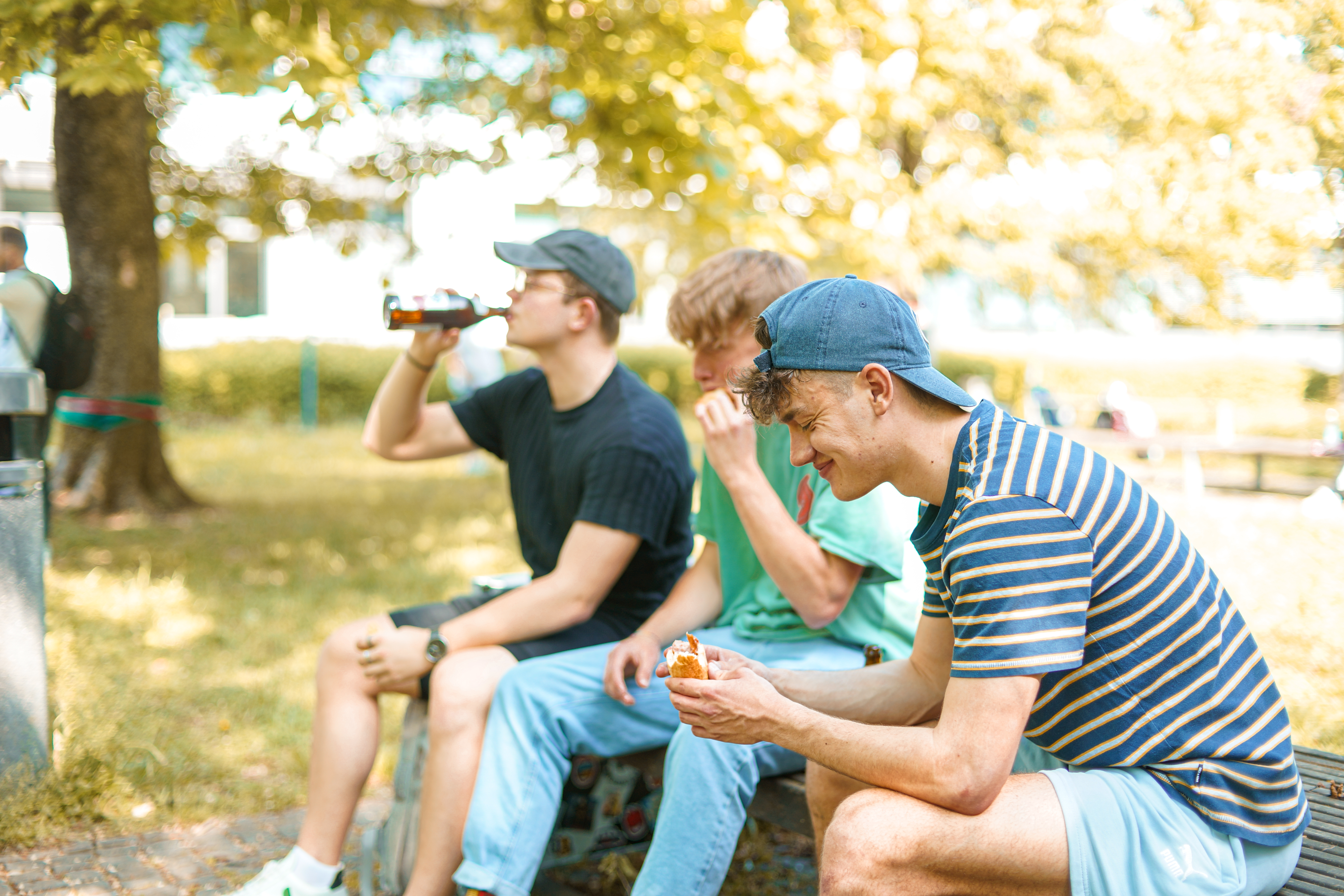Studierende sitzen draußen und essen und trinken