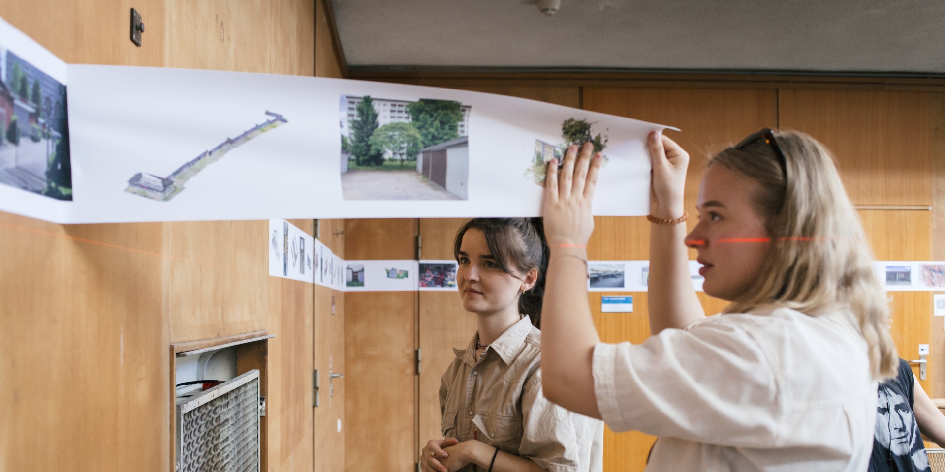 Studentinnen schauen Pläne an der Wand an