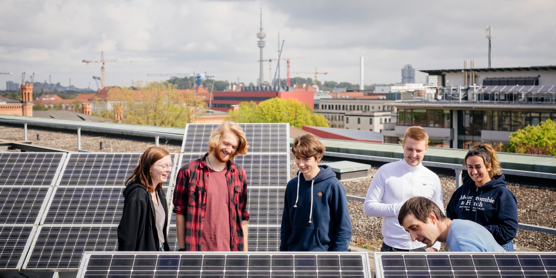 Studierende auf dem Dach mit Solarpanels