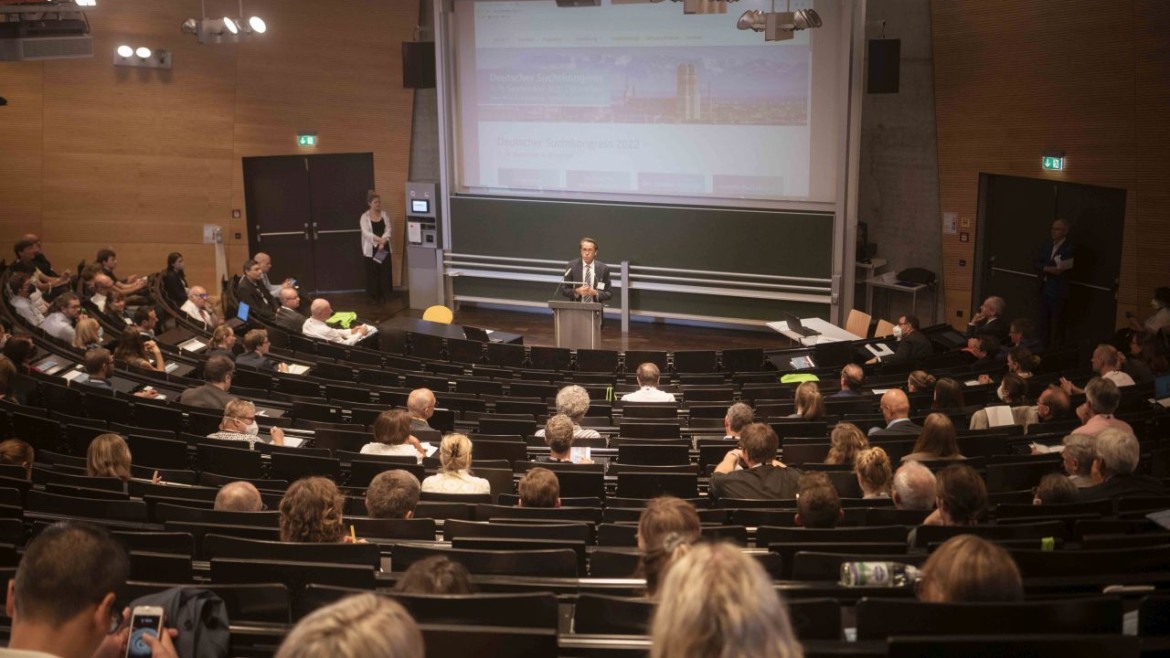 Sprecher hält Vortrag vor Teilnehmenden des Suchtkongresses 2022 im Hörsaal an der Hochschule München