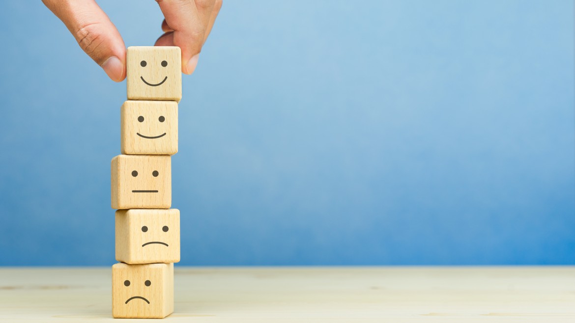 Evaluation der Lehre (Foto: Worawut – stock.adobe.com) Fröhliche und traurige Smileys auf Holzklötzen