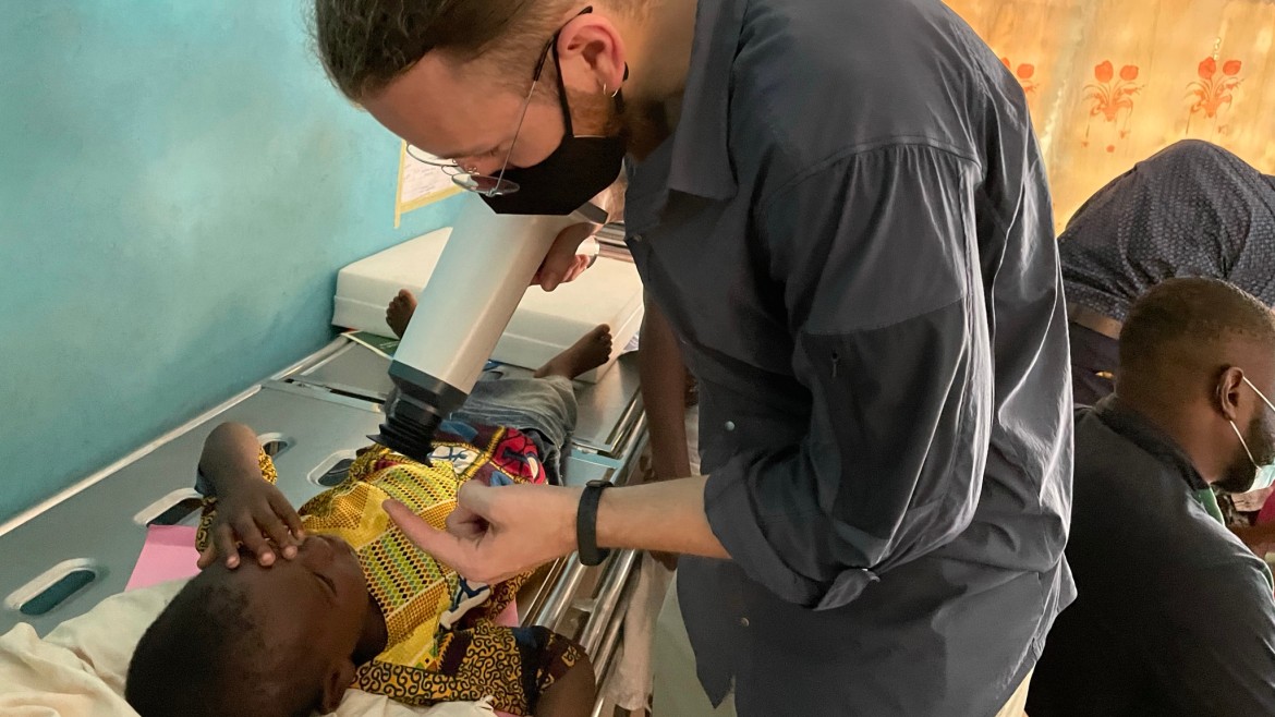Ein Studierender untersucht ein Kind (Foto: Projektgruppe Moritz Lippok/Kumasi) Ein Student untersucht ein Kind, dass auf einer Untersuchungsliege liegt