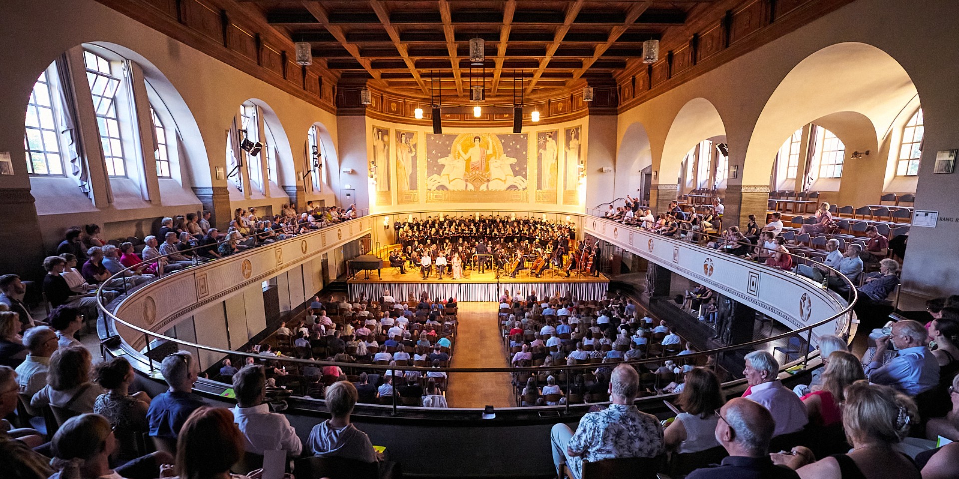 Zwei Schöpfungsgeschichten in einer: Chor und Symphonieorchester der Hochschule München führen Joseph Haydn und Christoph Enzel in der großen Aula der LMU auf