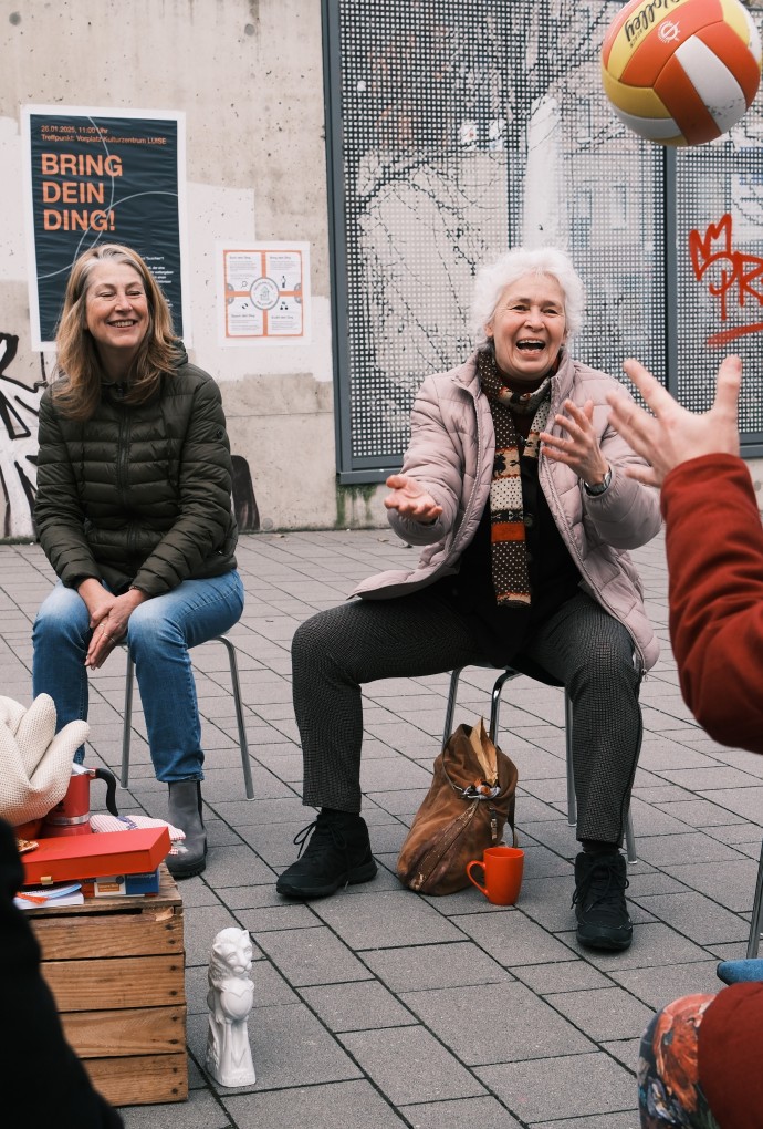 Frau wirft einer Person einen Ball zu