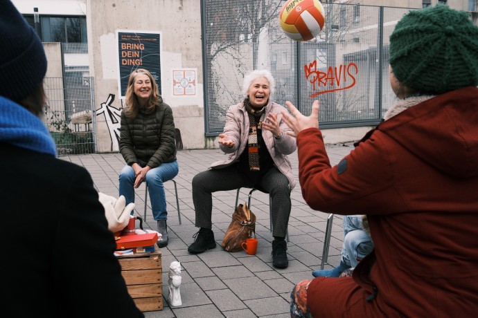 Frau wirft einer Person einen Ball zu