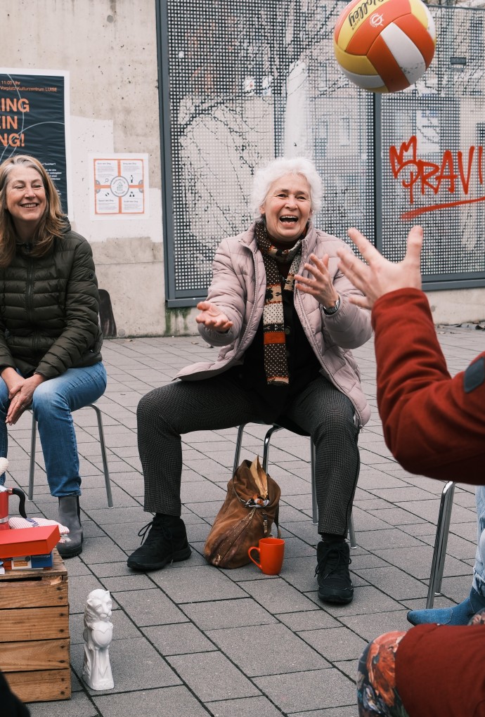 Frau wirft einer Person einen Ball zu