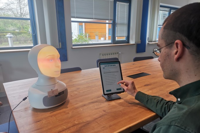 Ein Mensch unterhält sich mit dem Kopf eines Roboters (Foto: Irene Grandi) Ein Mensch unterhält sich mit dem Kopf eines Roboters