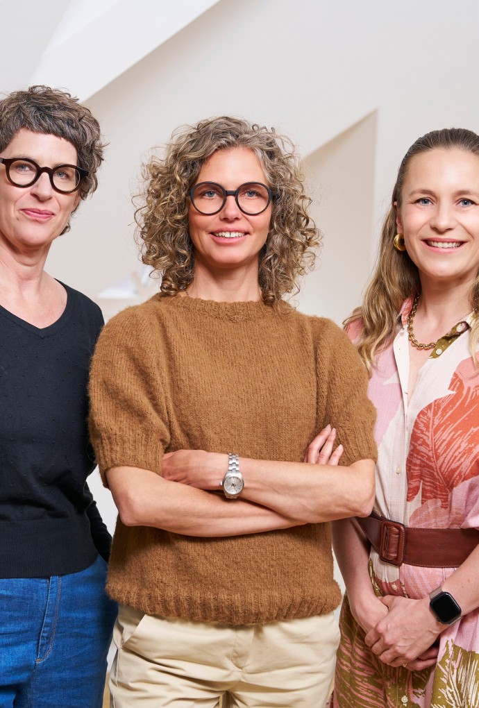 Die drei Frauenbeauftragte der Hochschule München stehen nebeneinander und blicken freundlich in die Kamera.