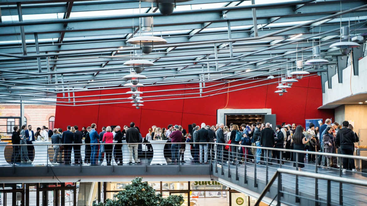 Festaktim Foyer des Roten Würfels (Foto: Johanna Weber) Studierende, Lehrende und Gäste stehen im Foyer des Roten Würfels