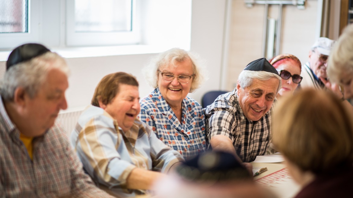 Ältere Jüdinnen und Juden sitzen in lustiger Runde