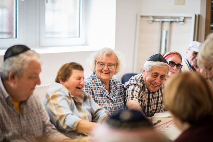 Ältere Jüdinnen und Juden sitzen in lustiger Runde