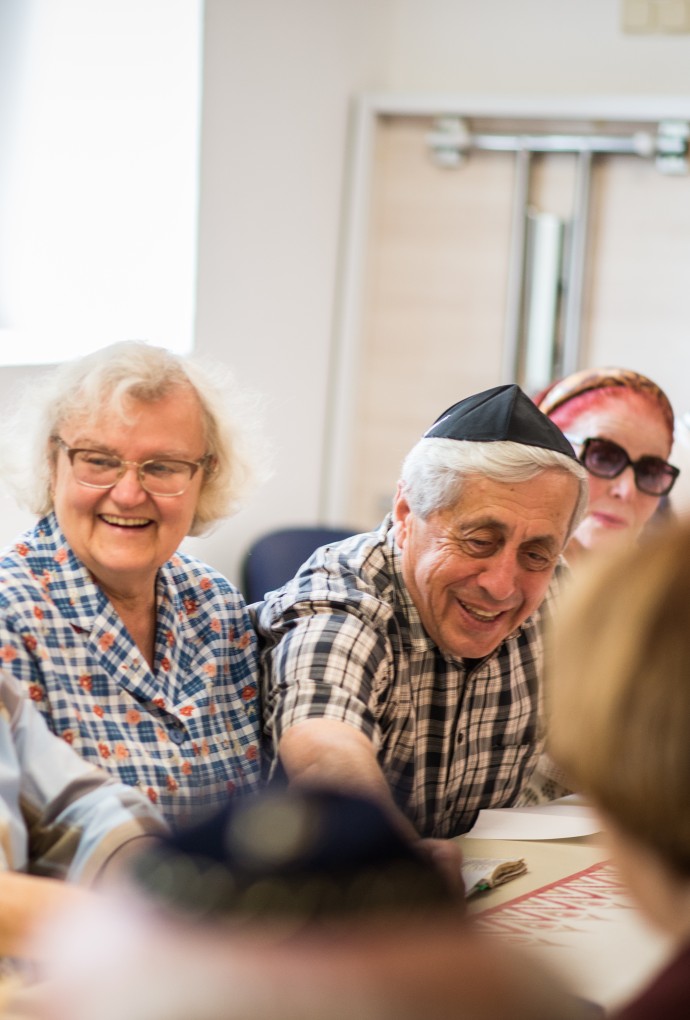 Ältere Jüdinnen und Juden sitzen in lustiger Runde