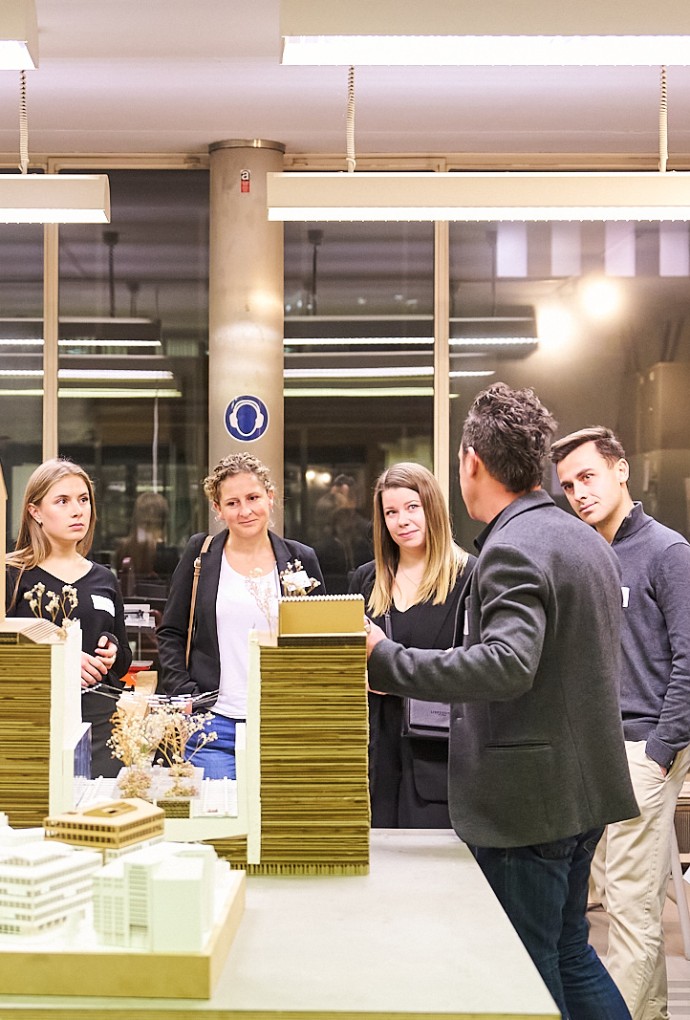 Menschengruppe betrachtet Gebäudemodelle