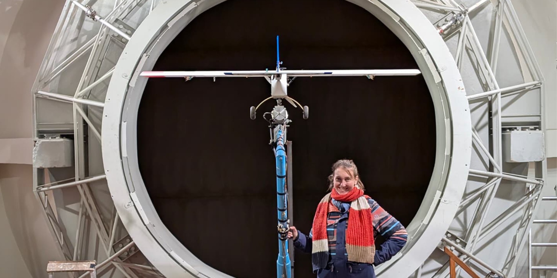 Ein Modellflugzeug im Windkanal mit Forscherin 