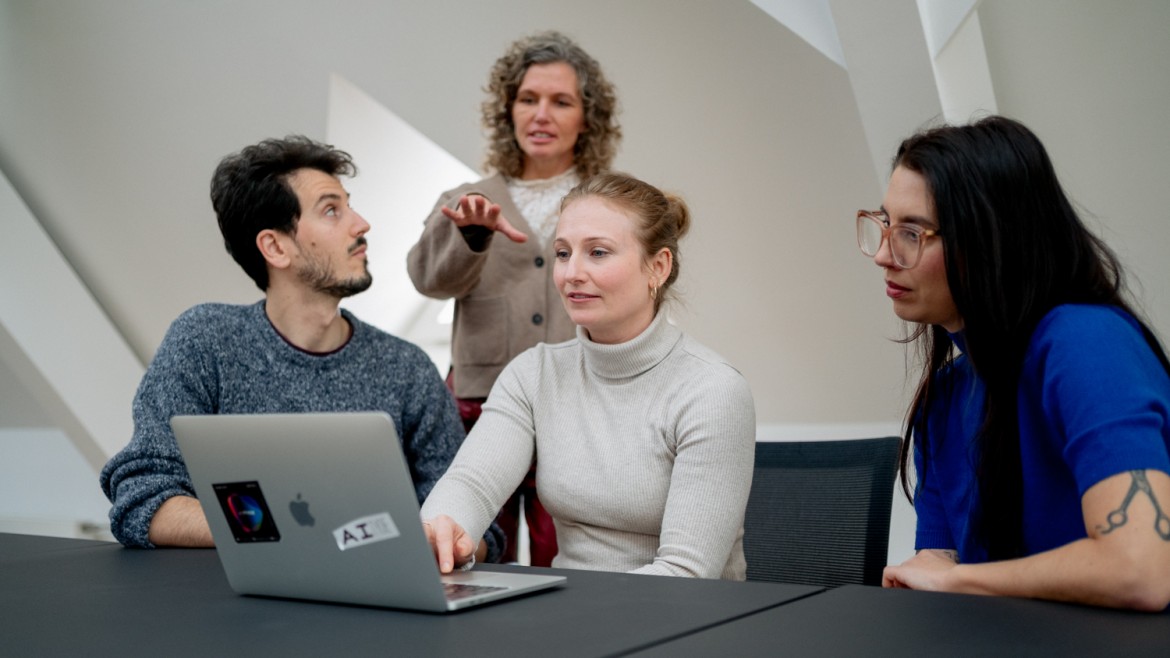 Wissenschaftlerinnen und Wissenschaftler sitzen vor Laptop und diskutieren