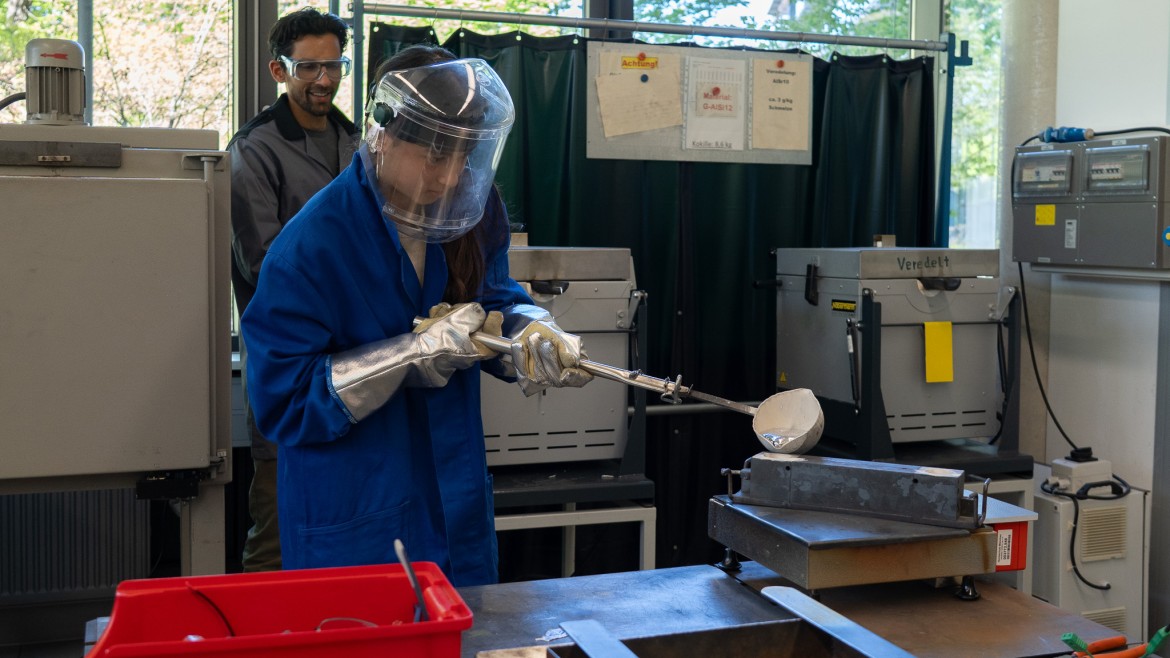 Teilnehmerin am Girls Day der HM gießt heißes Metall in Form