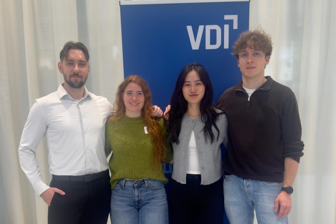Vier HM-Studierende stehen vor einem Plakat des VDI Wettbewerbs