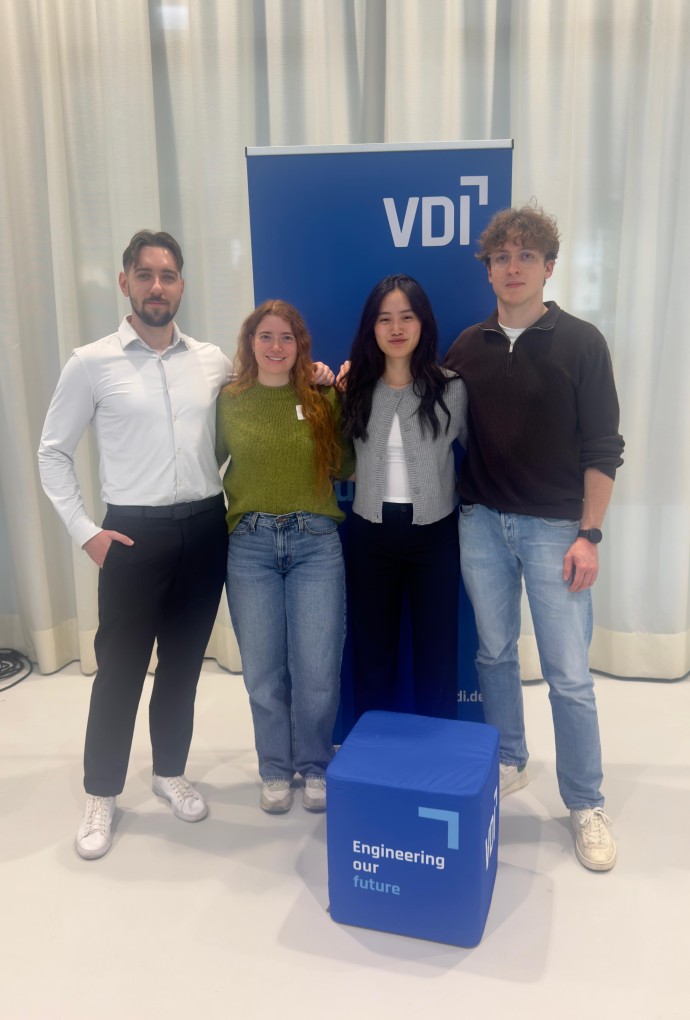 Vier HM-Studierende stehen vor einem Plakat des VDI Wettbewerbs