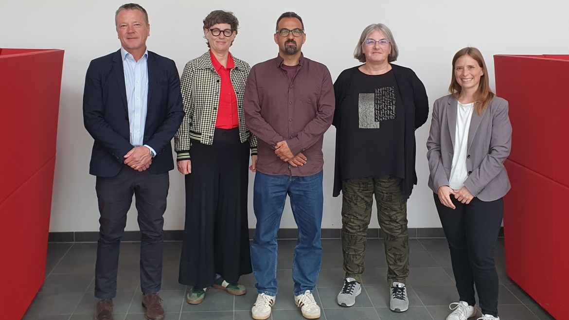 Vier Personen stehen nebeneinander und lächeln in die Kamera: HM-Professor Ralph-Miklas Dobler, HM-Professorin Gabriele Fischer, HM-Promovent Çağan Varol und Prof. Dr. habil. Clarissa Rudolph (OTH Regensburg)