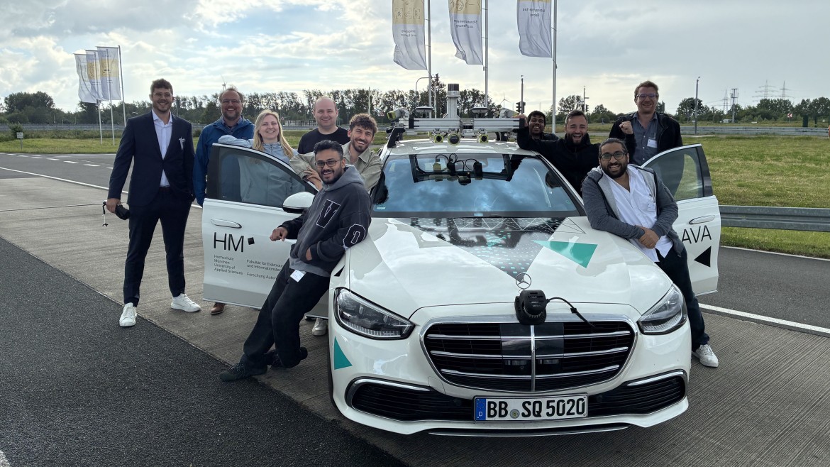 Forschende der Hochschule München mit Testfahrzeug für autonomes Fahren