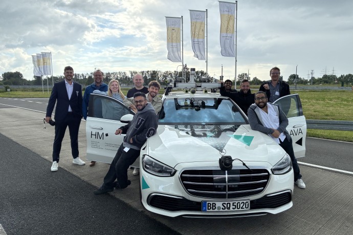Forschende der Hochschule München mit Testfahrzeug für autonomes Fahren