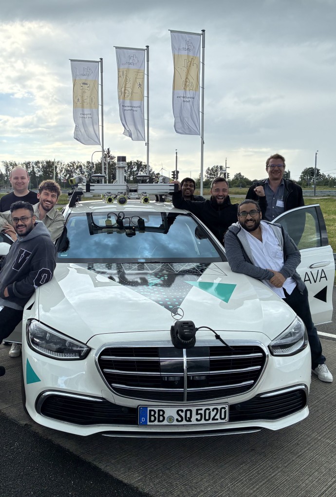 Forschende der Hochschule München mit Testfahrzeug für autonomes Fahren