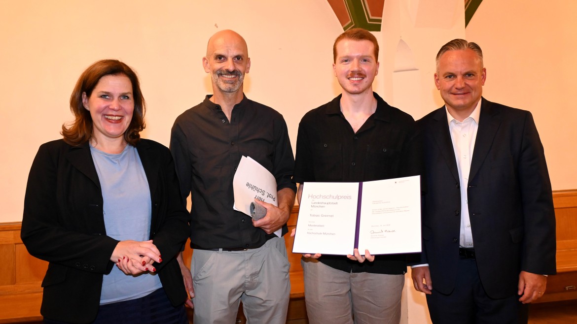 Tobias Greimel (2. v. r.) hält seine Urkunde zum Hochschulpreis 2026 in den Händen. Neben ihm stehen die Dritte Bürgermeisterin Verena Dietl, HM-Professor Christian Schühle und der Referent für Arbeit und Wirtschaft, Dr. Christian Scharp