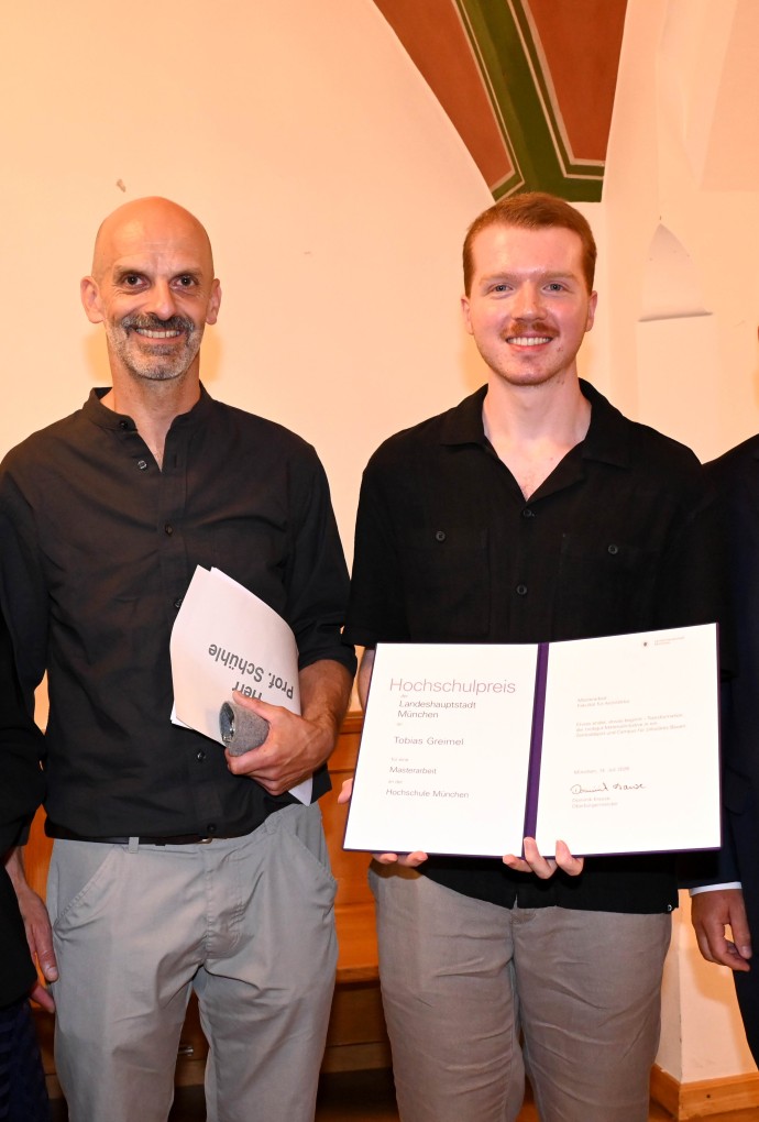 Tobias Greimel (2. v. r.) hält seine Urkunde zum Hochschulpreis 2026 in den Händen. Neben ihm stehen die Dritte Bürgermeisterin Verena Dietl, HM-Professor Christian Schühle und der Referent für Arbeit und Wirtschaft, Dr. Christian Scharp