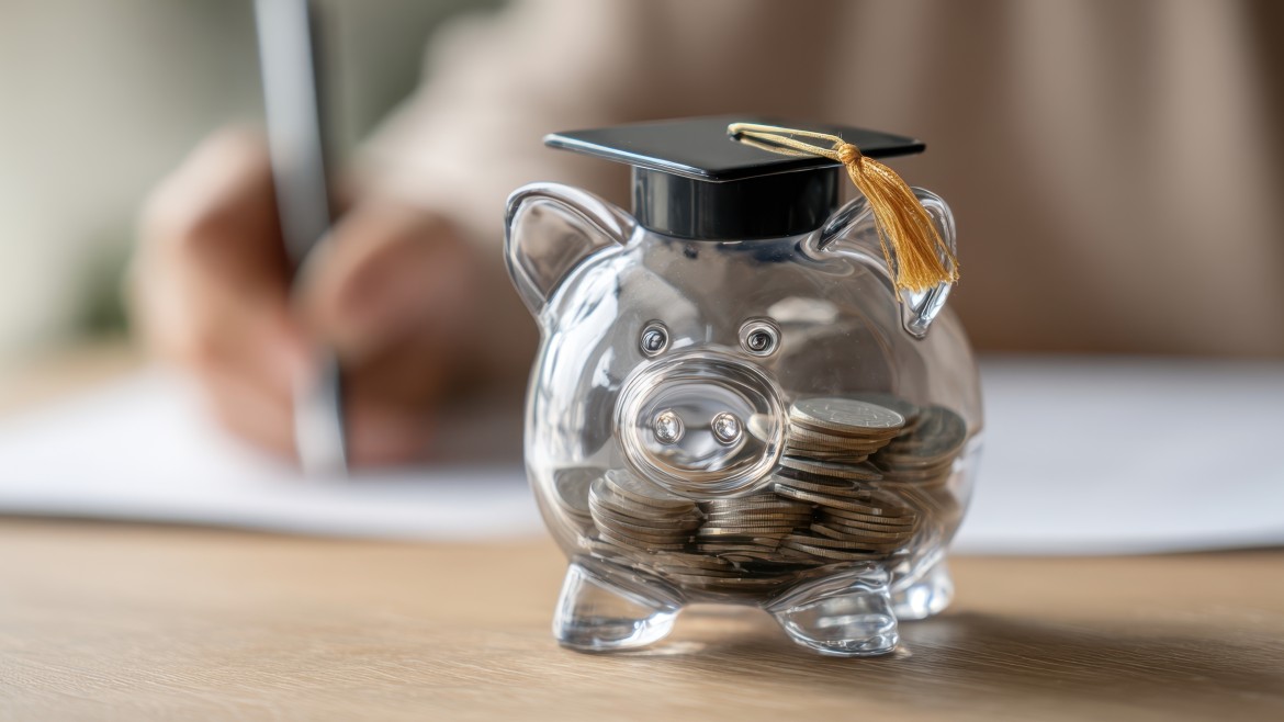 Gläsernes, mit Münzen befülltes Sparschwein.